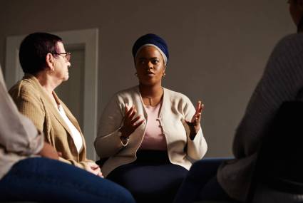 Support, black woman and senior group therapy with understanding, feelings and talking in session. .