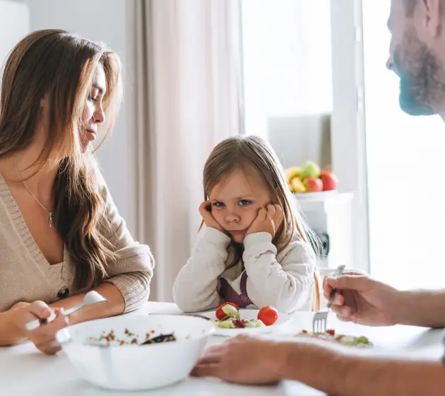 unhappy-little-girl-with-her-parents-at-table-2026-03-10-01-07-49-utc